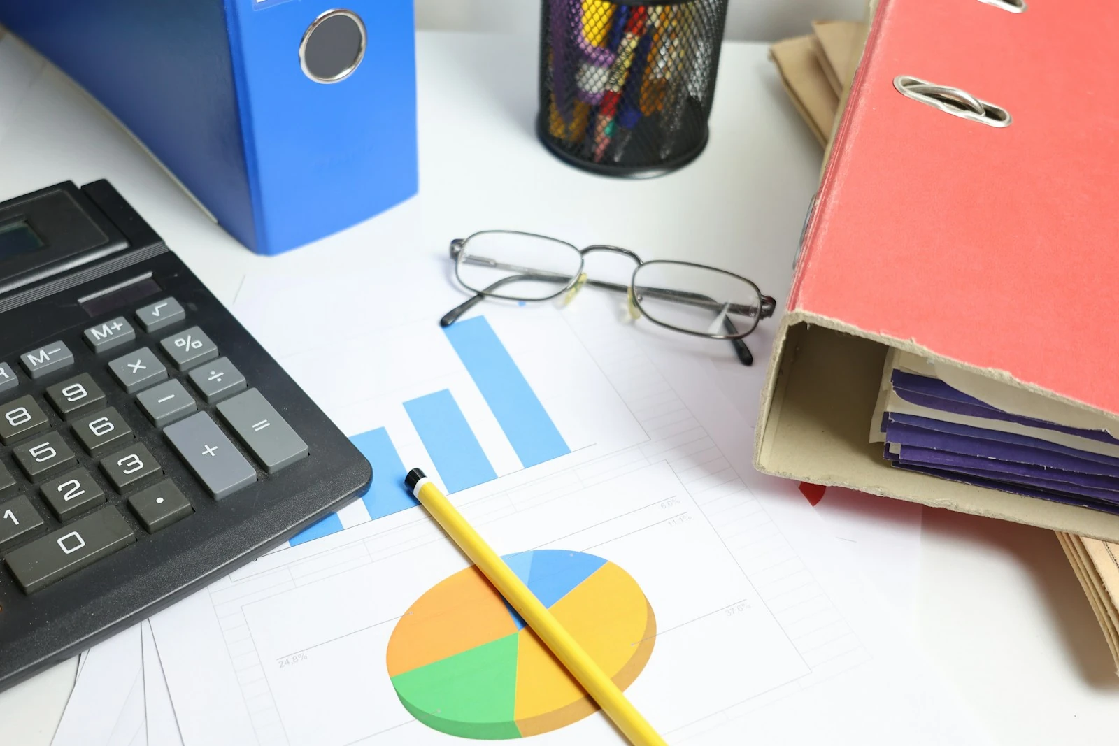 Calculator, charts and accounting binders on a desk