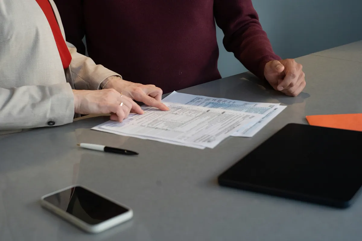 Broker and client reviewing a financial document together at a desk