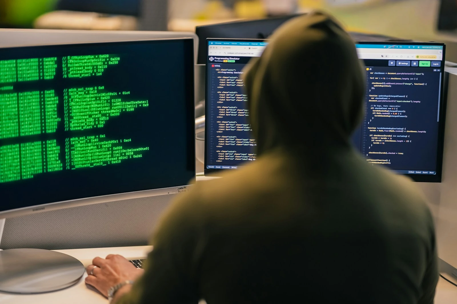 Cybersecurity professional working at multiple computer screens
